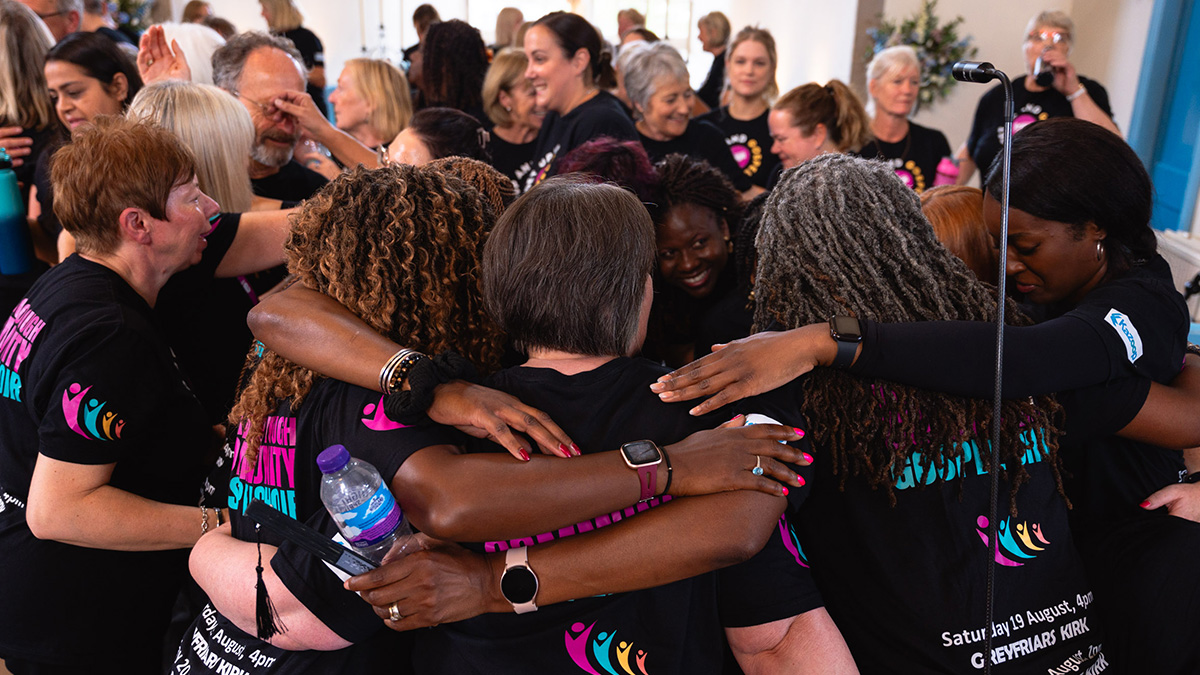 Wellingborough Community Gospel Choir hugging after a performance at Canongate Kirk in Edinburhg during the Fringe Festival