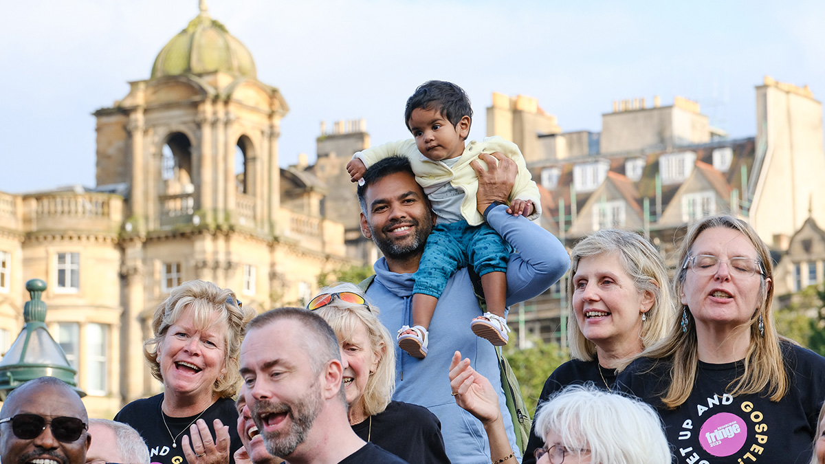 A happy parent and child getting involved with a performance from Wellingborough Community Gospel Choir in Edinburgh at the Fringe Festival