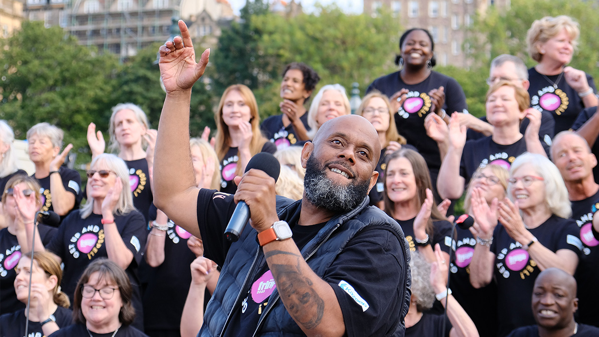 Wellingborough Gospel Choir, led by their Choir Director, clap and sing on top of the Mound during the Edinburgh Fringe.
