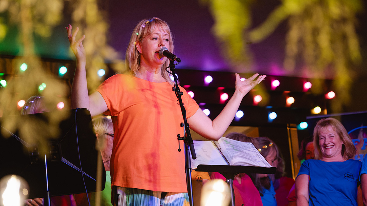 Choir leader of Fab Choir speaks with the crowd in Brewhemia.