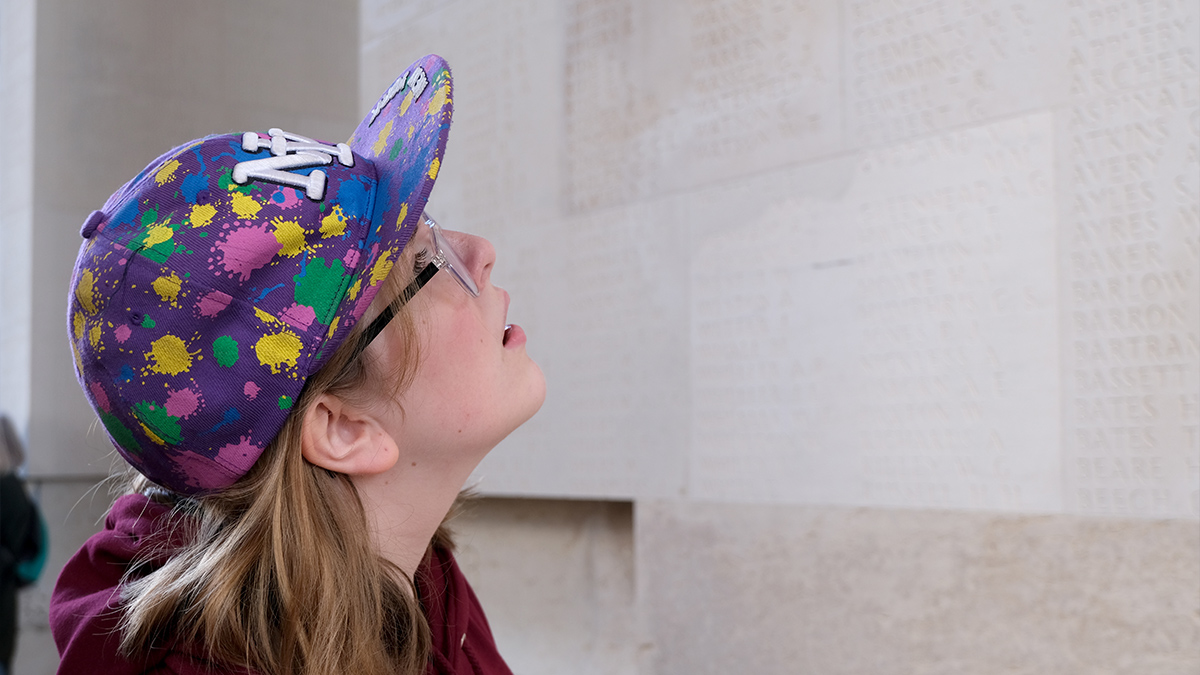 Students looks at the names on a memorial