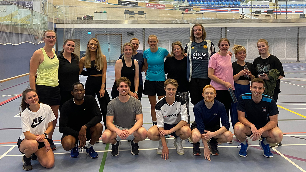 17 players in a group on the netball court at Derby Arena