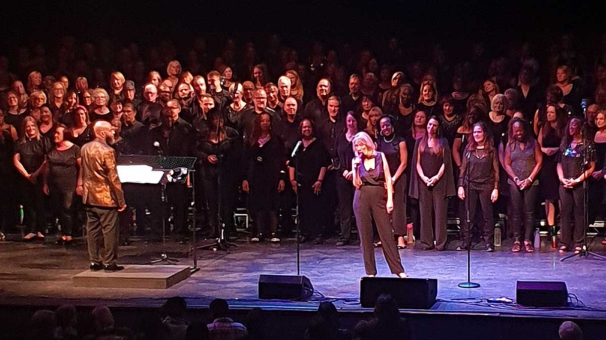 Conductor and soloist at the front of the choir on stage