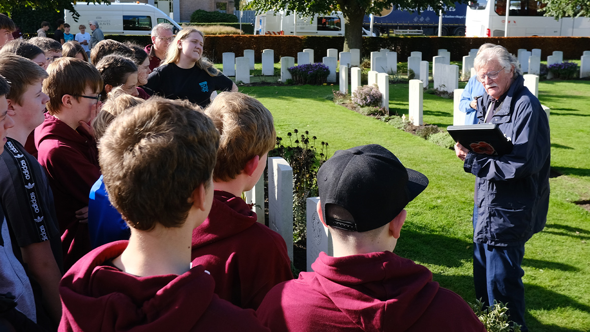 Trevor booker, History Tour Guide, engages history students at a cemetery.