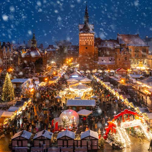 Beautifully lit Christmas market in the Main City of Gdansk during a snowfall, Poland, is one of many Christmas traditions from around the world.