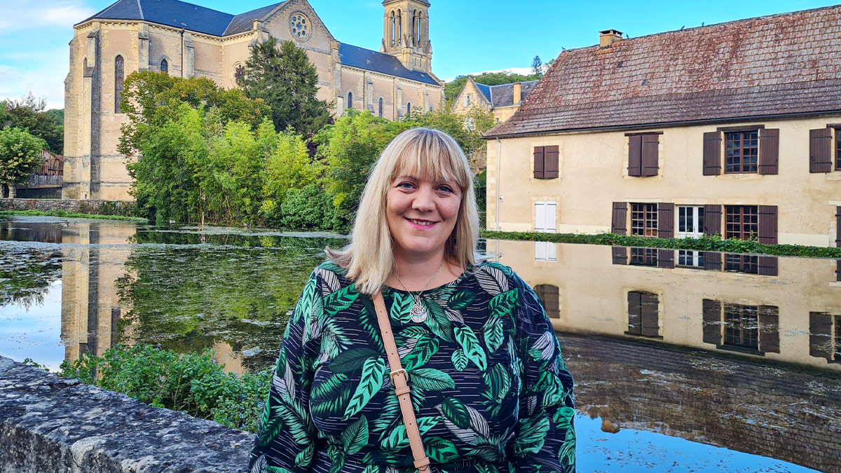 Language Champion Eleanor Harvey posing in front of a moat and village.