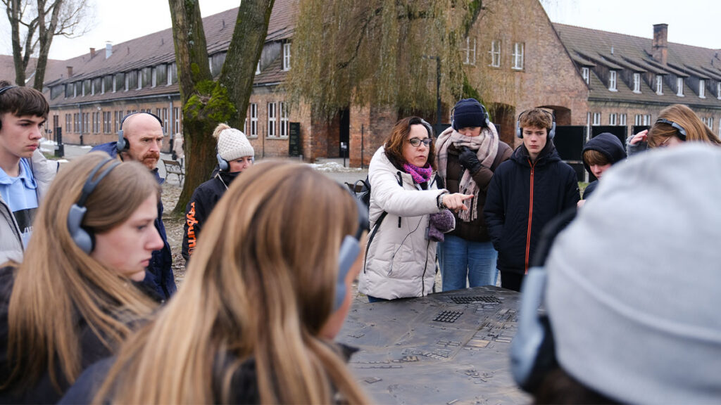 History tour guide with a school group at Auschwitz I Memorial