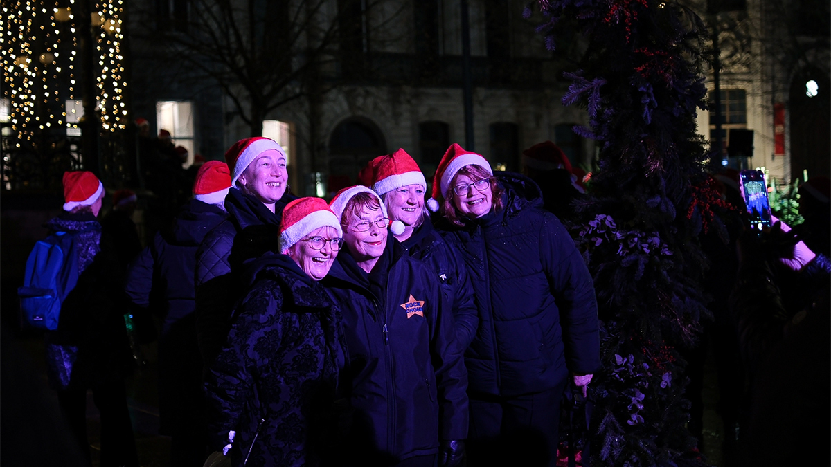 Rock Choir members taking a photo in front of purple lighting