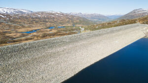Aerial photography of the majestic Sysen Dam in Norway, surrounded by mountainous landscape and lakes, bird s-eye view.