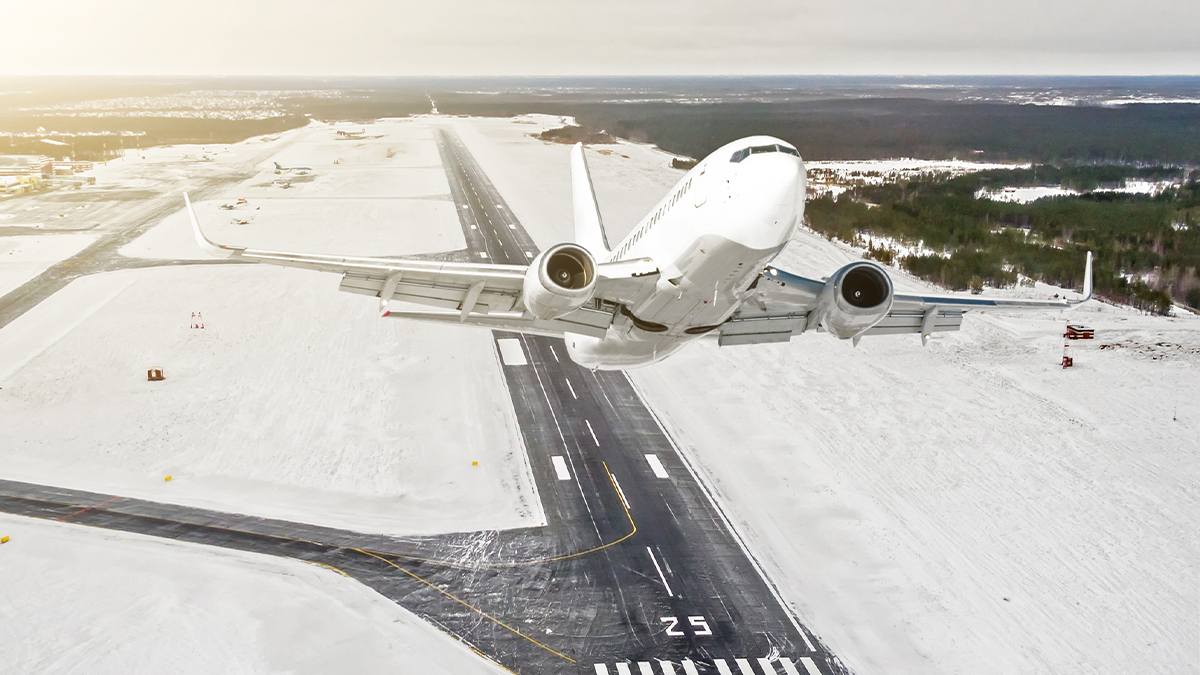 plane taking off from snowy runway