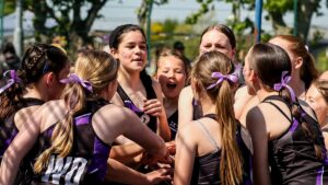 A youth team huddling after winning a game of netball