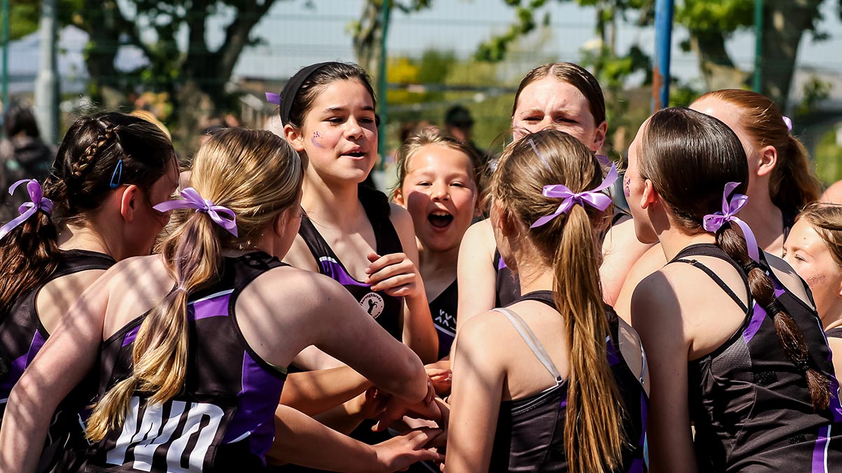 A youth team huddling after winning a game of netball