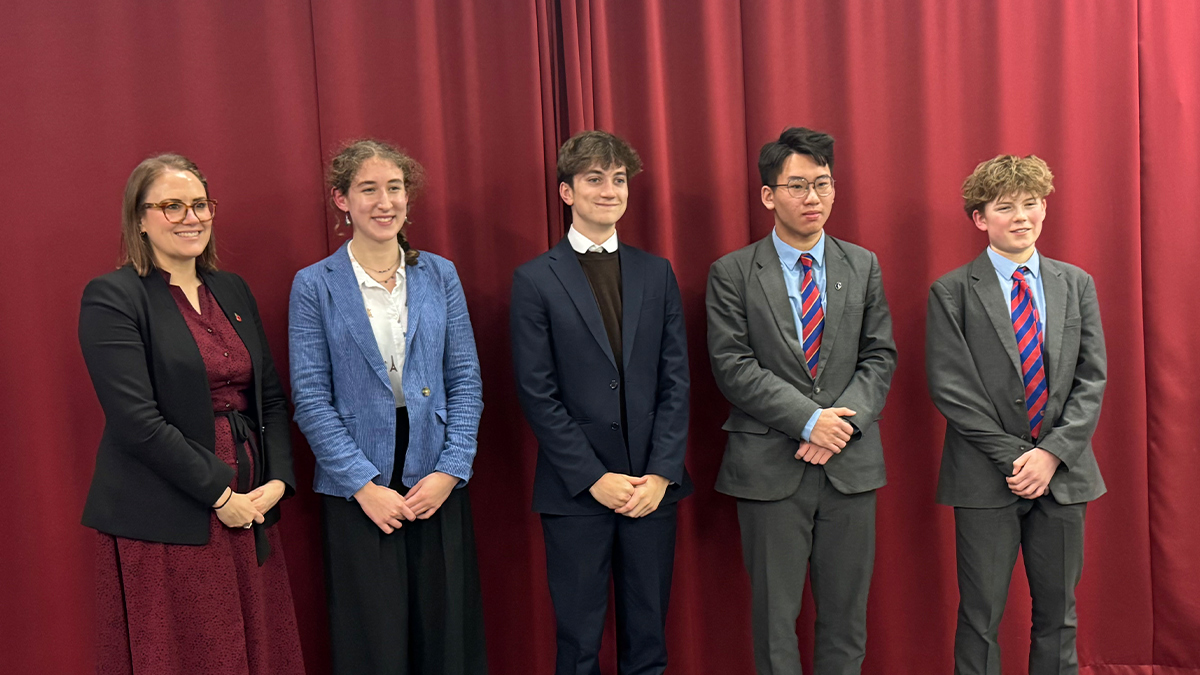 picture from students at the Great Debate with a red curtain backdrop